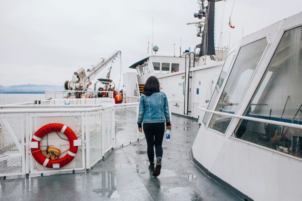 Femme de dos sur pont d'un gros bateau