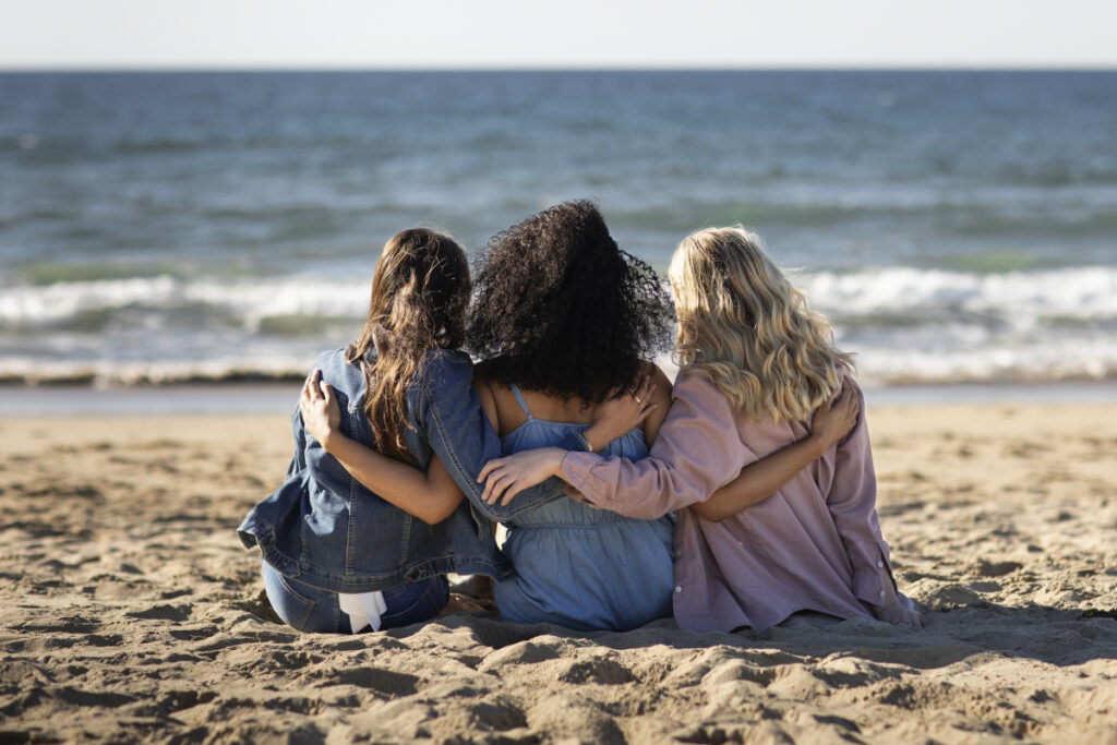 Visu article : famille se tenant assises devant la mer de dos